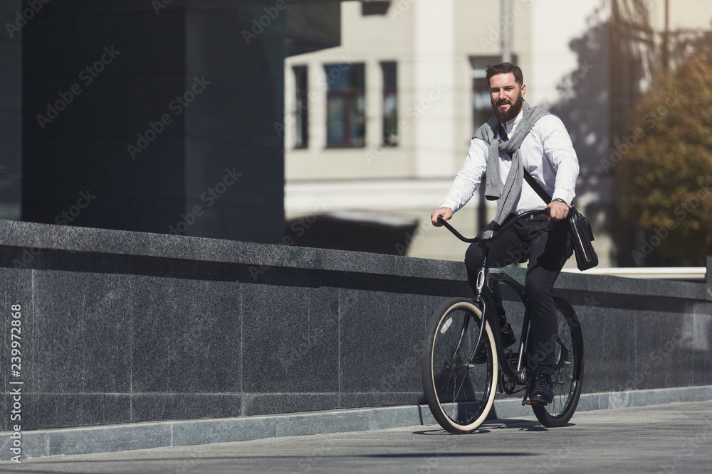 Handsome young businessman riding on his bicycle