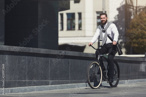 Handsome young businessman riding on his bicycle © Prostock-studio