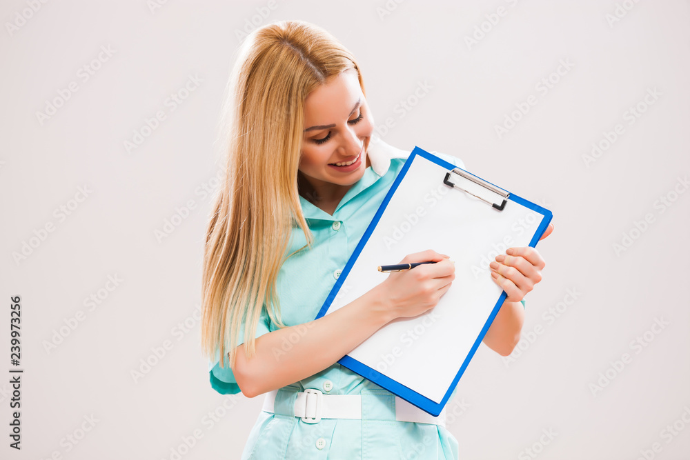 Portrait of young doctor who is holding clipboard and showing document with pen. Portrait of young doctor who is holding clipboard and showing document with pen.