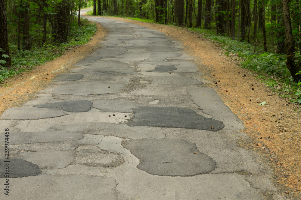 Old road repaired with asphalt patches