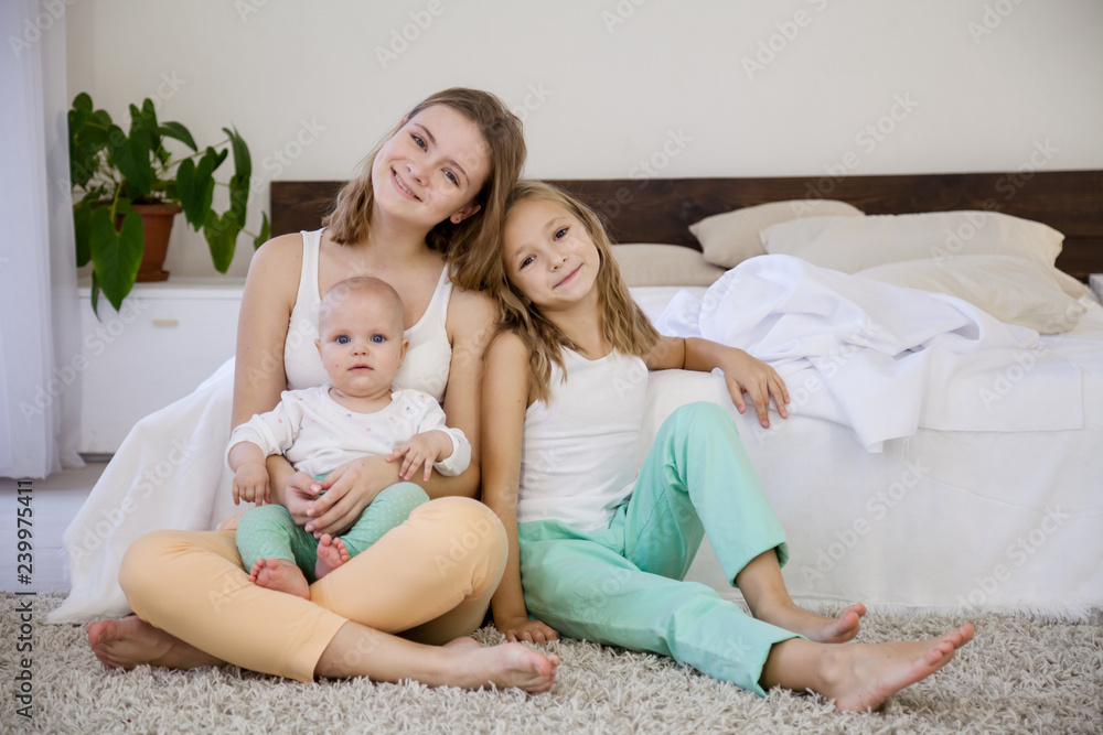 three girls sisters in the morning in the bedroom on the bed play three girls sisters in the morning in the bedroom on the bed play