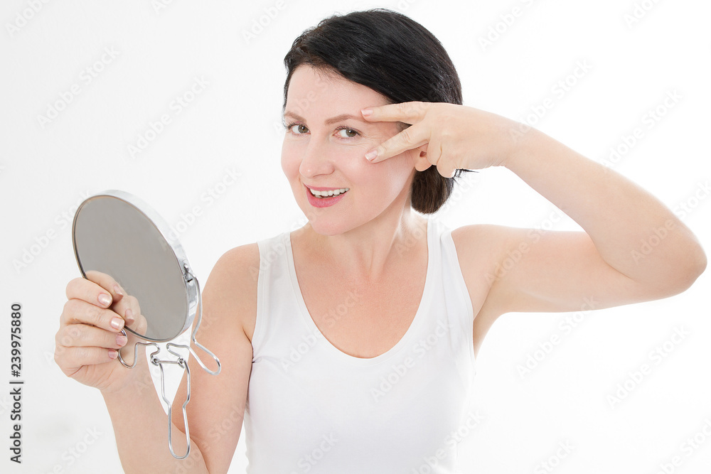 Beauty middle age woman with mirror. Face portrait. Spa and anti aging concept Isolated on white background. Plastic surgery and collagen face injections. Wrinkles and menopause. Mock up. Copy space Beauty middle age woman with mirror. Face portrait. Spa and anti aging concept Isolated on white background. Plastic surgery and collagen face injections. Wrinkles and menopause. Mock up. Copy space