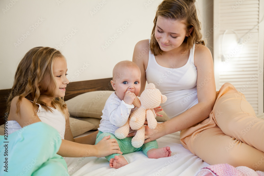 three girls sisters in the morning in the bedroom on the bed play three girls sisters in the morning in the bedroom on the bed play
