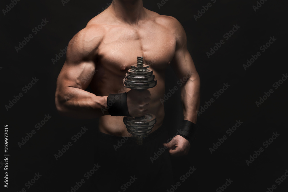Strong athletic man with dumbbell showes naked muscular body Strong athletic man with dumbbell showes naked muscular body