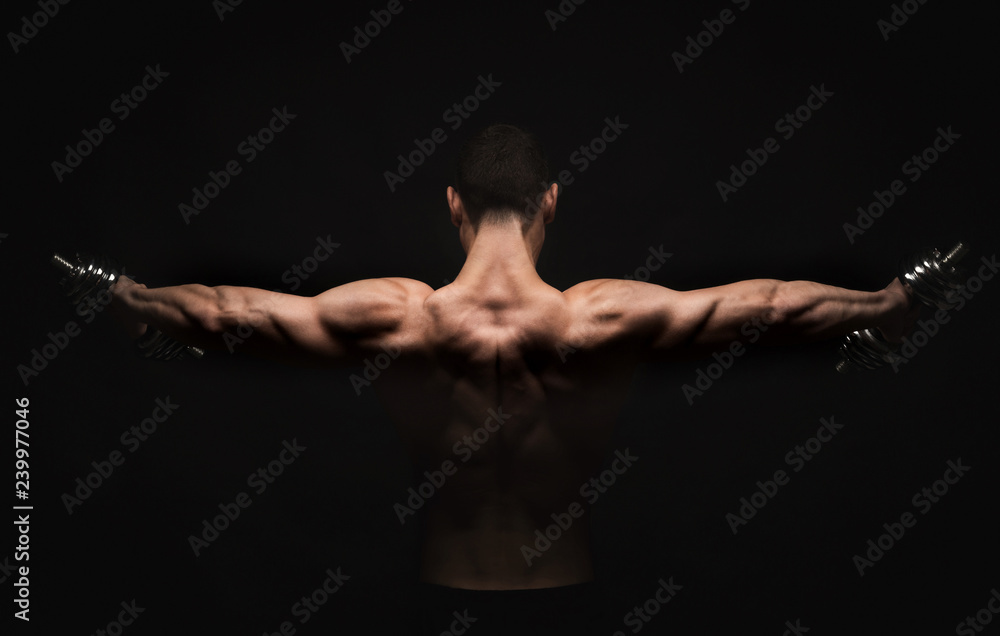 Unrecognizable man shows strong back muscles closeup Unrecognizable man shows strong back muscles closeup
