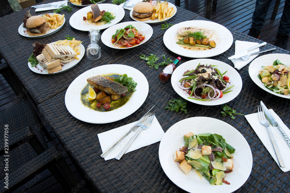 Mix Various Seafood, Spaghetti, club sandwich, burger, salad, hot spicy Foods on table over tropical ocean atmosphere, Top view camera dinner lunch together with friends family Mix Various Seafood, Spaghetti, club sandwich, burger, salad, hot spicy Foods on table over tropical ocean atmosphere, Top view camera dinner lunch together with friends family