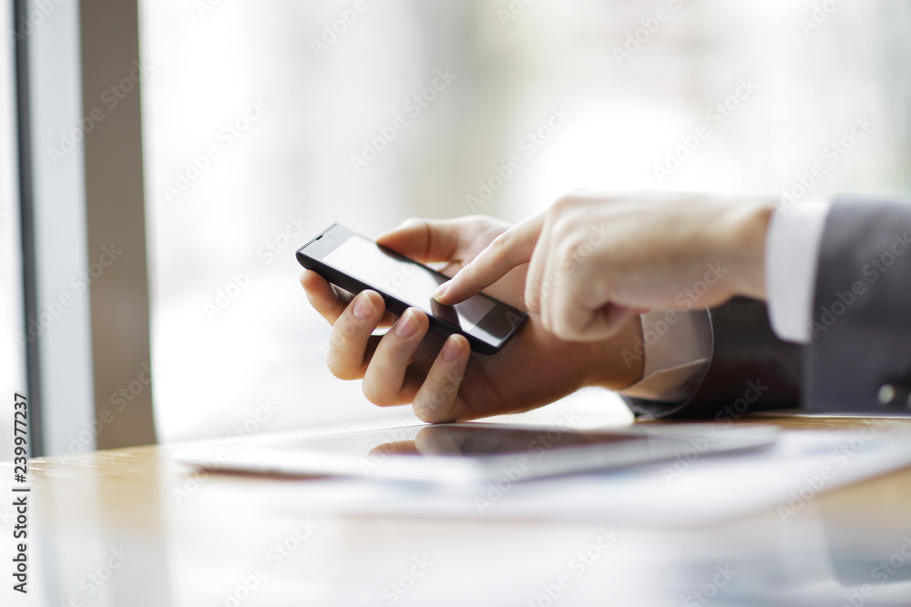 Fototapeta premium close up.businessman is typing SMS on a smartphone