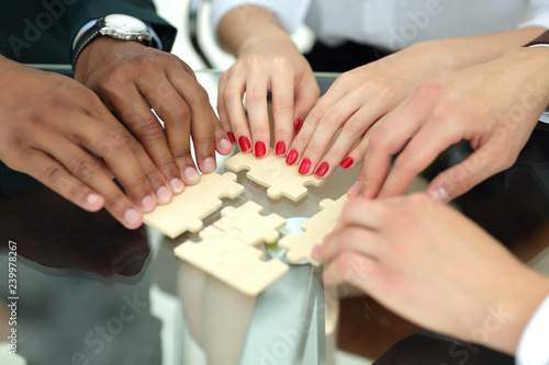 closeup. business team with puzzle pieces behind a Desk