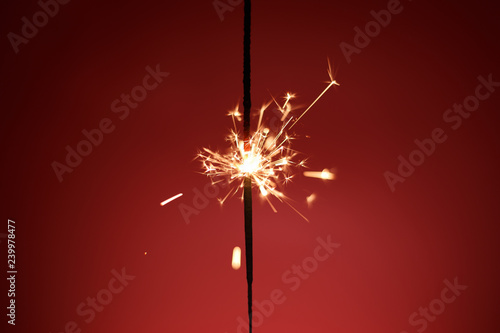  New Year's sparkler on a red background. Celebration