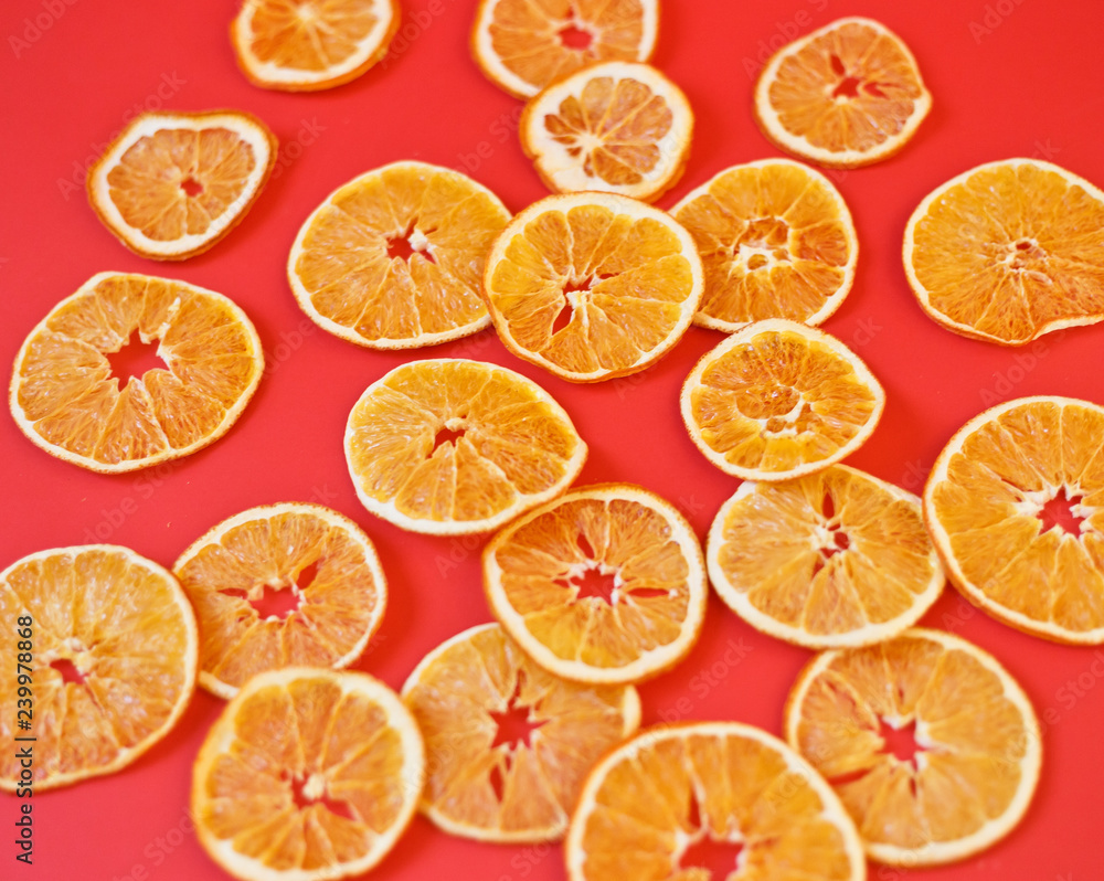 dried oranges laid out on a red background