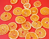 dried oranges laid out on a red background