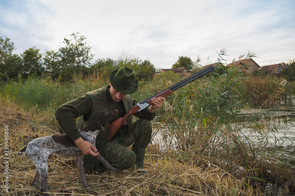 Hunter with riffle shotgun and hunting dog Hunter with riffle shotgun and hunting dog