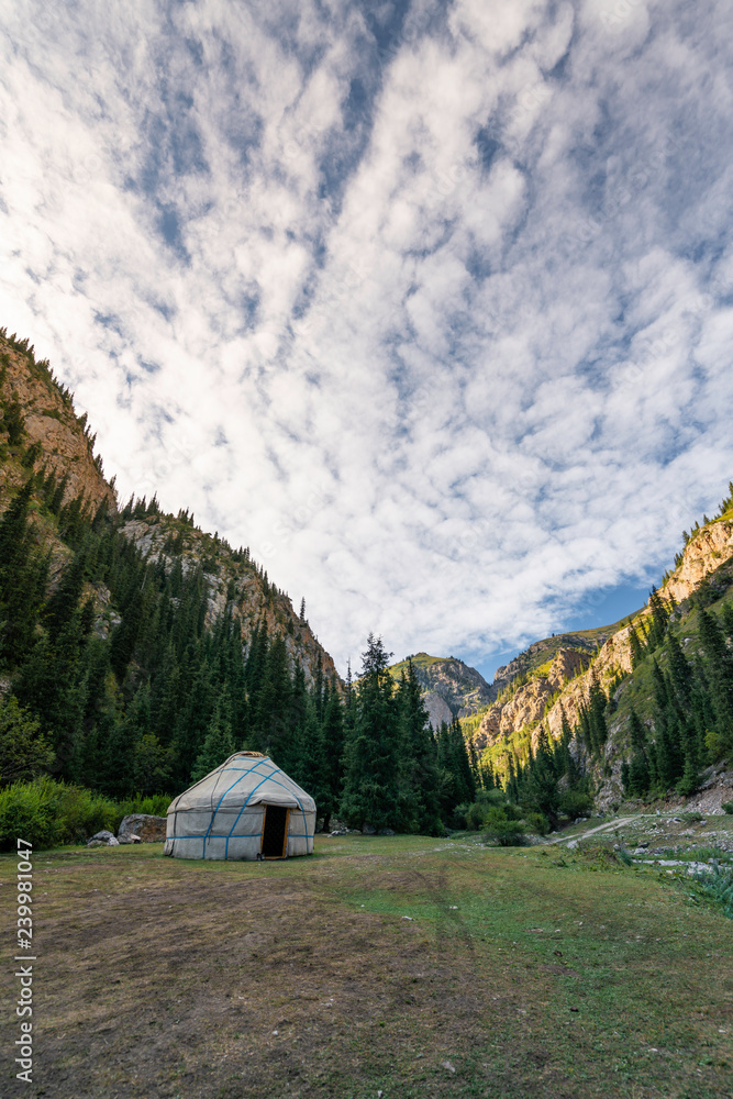 Single yurt between the mountains at sunset in Kyrgyzstan