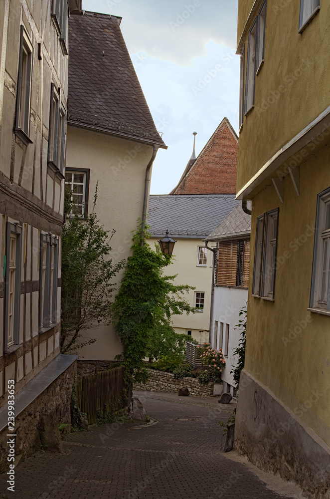 Narrow cobblestone street with colorful medieval buildings in a residential part of the Wetzlar city. Wetzlar, State of Hesse, Germany