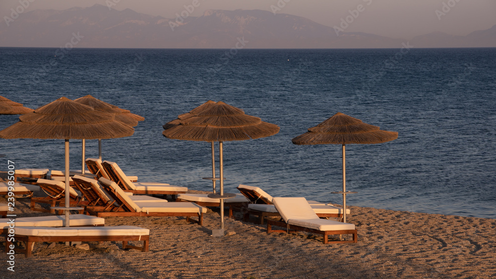 Parasols et bains de soleil sur la plage de Kos au crepuscule