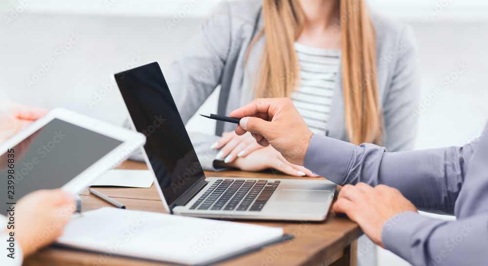 Business executives pointing at laptop screen at meeting Business executives pointing at laptop screen at meeting