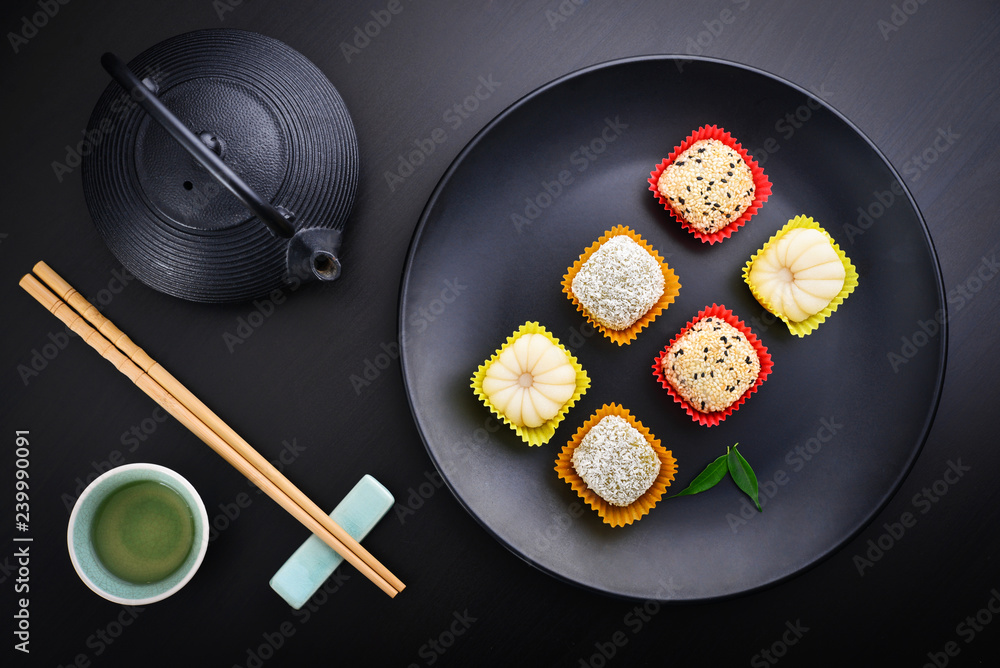 Mochi assortment on plate with chopticks and green tea Mochi assortment on plate with chopticks and green tea