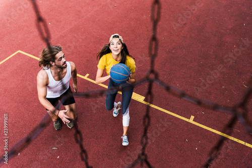 Friends playing basketball on basketball court © Westend61