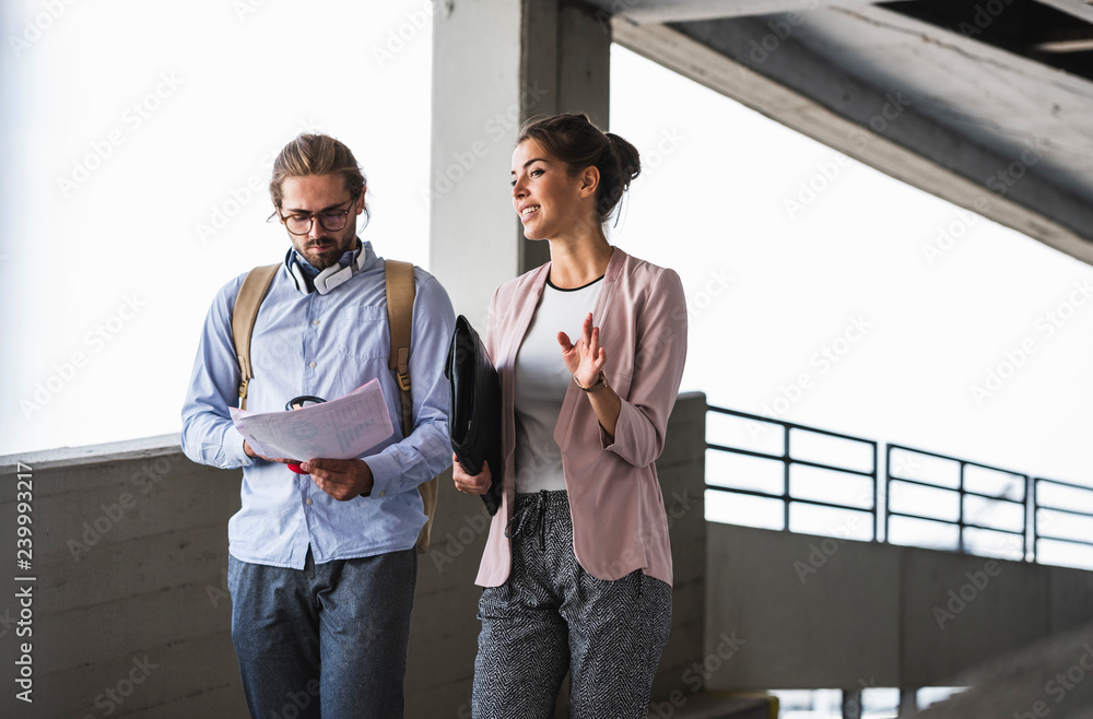 Young business people discussing document on their way to work Young business people discussing document on their way to work