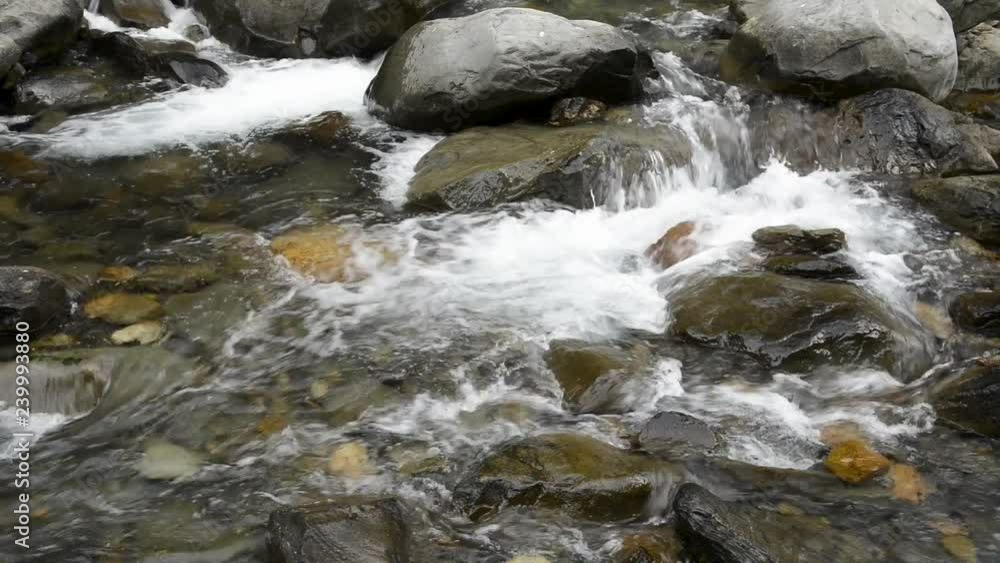 Water flow in a rocky creek spray with white splash Water flow in a rocky creek spray with white splash