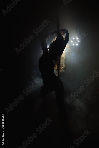 Pretty woman dancing in a pole dance studio