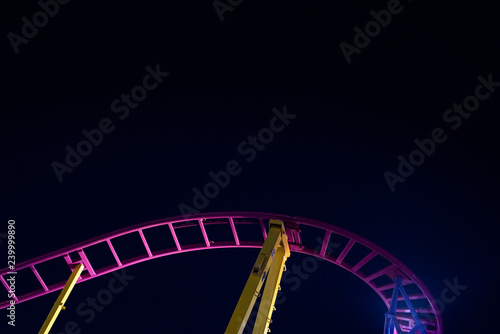 Rails of a roller coaster, blue night sky background.