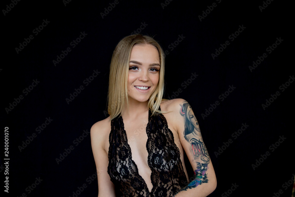 a studio shot of a young woman with tattoo a studio shot of a young woman with tattoo