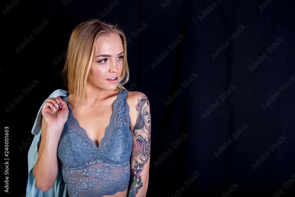 a studio shot of a young woman with tattoo a studio shot of a young woman with tattoo