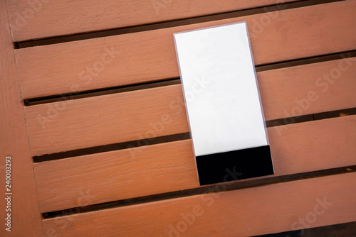 White plastic board on wooden table background.