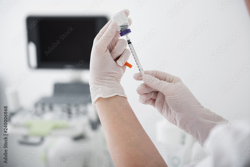 Hands in rubber gloves holding syringe and injection bottle Hands in rubber gloves holding syringe and injection bottle