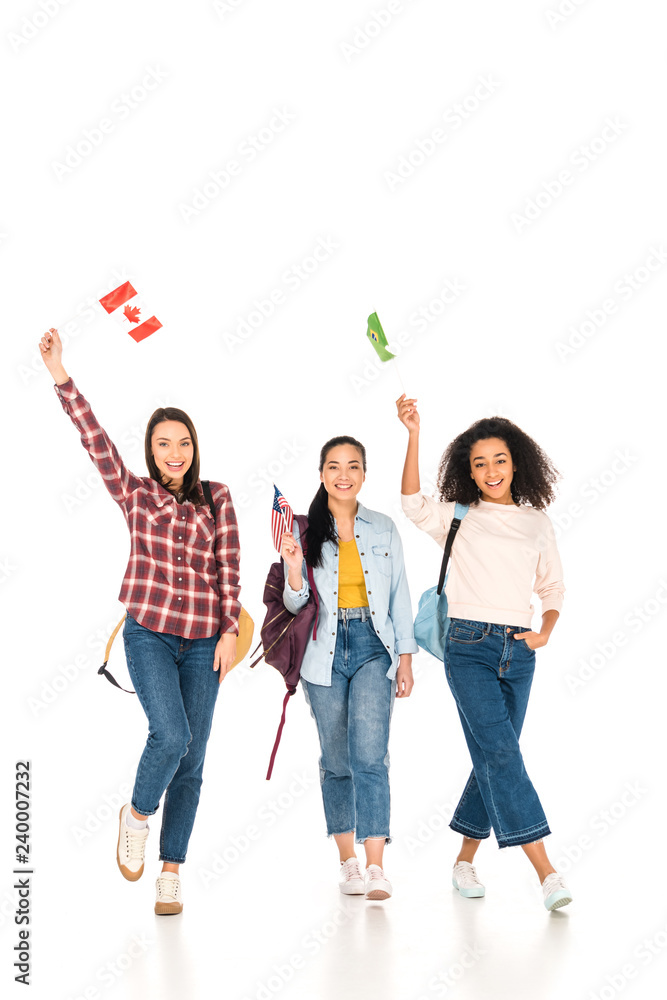 Obraz premium beautiful girls with flags of different countries above heads isolated on white