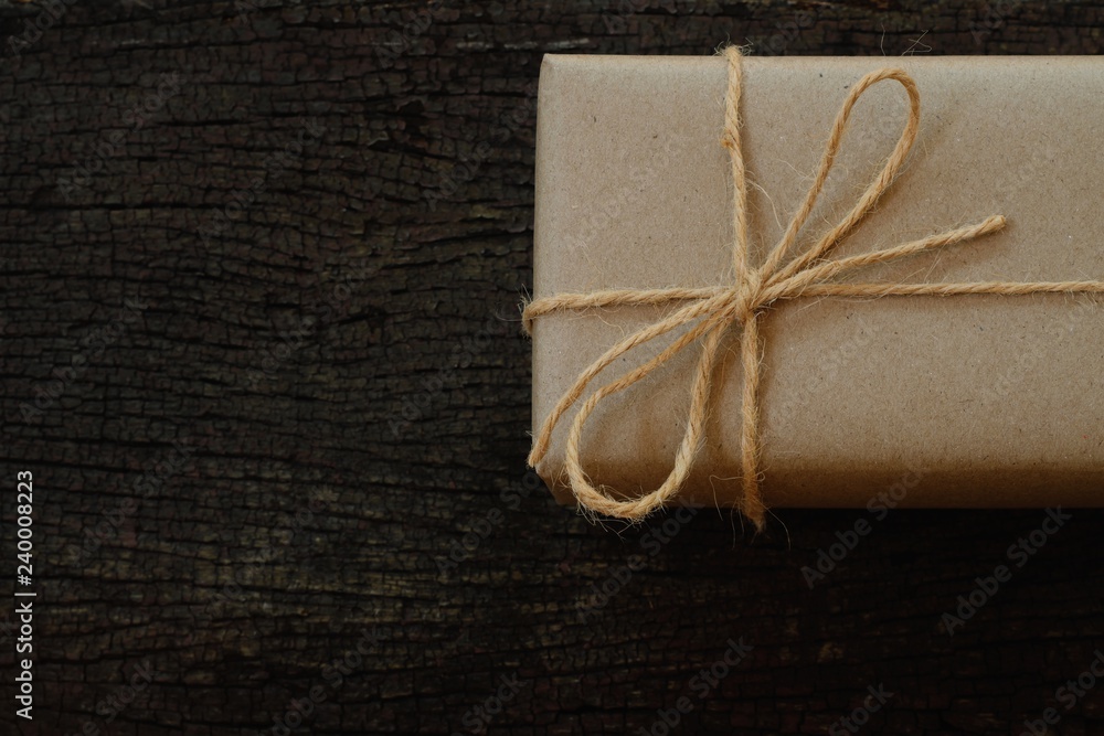 Simple eco friendly gift boxes package wrap with brown paper in old wooden table background, green present concept Simple eco friendly gift boxes package wrap with brown paper in old wooden table background, green present concept