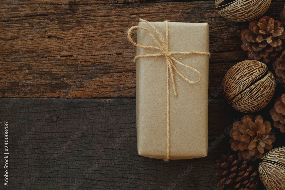 Fototapeta premium Simple eco friendly gift boxes package wrap with brown paper in old wooden table background, green present concept
