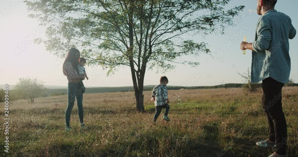 Four family members at nature spending perfect time together , two little boys making bubbles sunny summer day. 4k Four family members at nature spending perfect time together , two little boys making bubbles sunny summer day. 4k