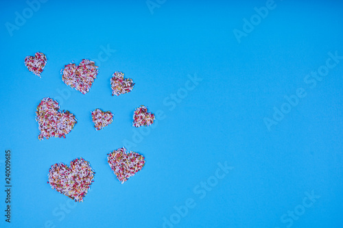 Multicolored confectionery noodle hearts on blue background. St. Valentine's Day