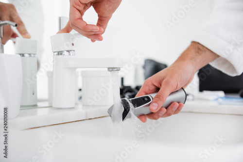 Close up of person washing the shaving machine