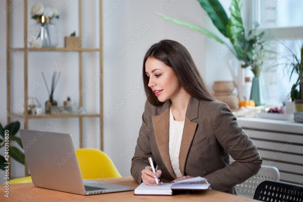 stylish business brunette works at a laptop. stylish business brunette works at a laptop.