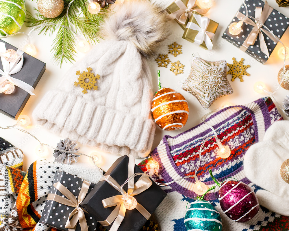 Christmas mood composition with Christmas sweater, hat, presents and lights. Winter concept flat lay, top view