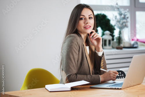 stylish business brunette works at a laptop.