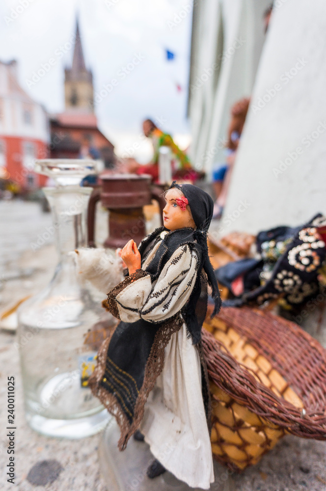 Obraz premium Traditional puppet in bazar with The Lutheran Cathedral of Saint Mary from Sibiu in fundal