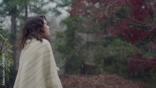 Very chilly woman tries to stay warm as snow flurries come down in early winter