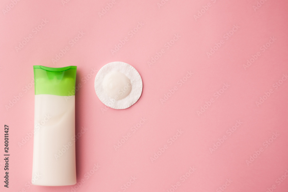 cleansing cream for the face and a cotton pad with a remuver. pink background. makeup removal. skin care. top view. selective focus. cleansing cream for the face and a cotton pad with a remuver. pink background. makeup removal. skin care. top view. selective focus.