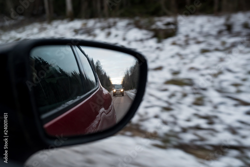 looking back in a side mirror at a car