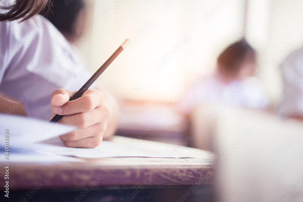 Hand of students writing exam in classroom with stress Hand of students writing exam in classroom with stress