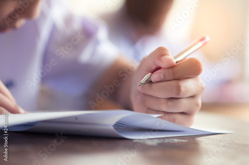 Hand of students writing exam in classroom with stress