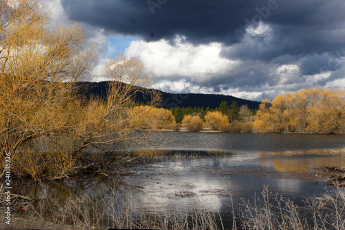 The dark storm clouds of Spring move over the lake photo