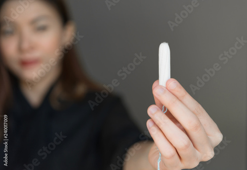 Woman holding menstruation tampon in hand,Menstrual tampon. Menstruation time. Hygiene and protection. photo