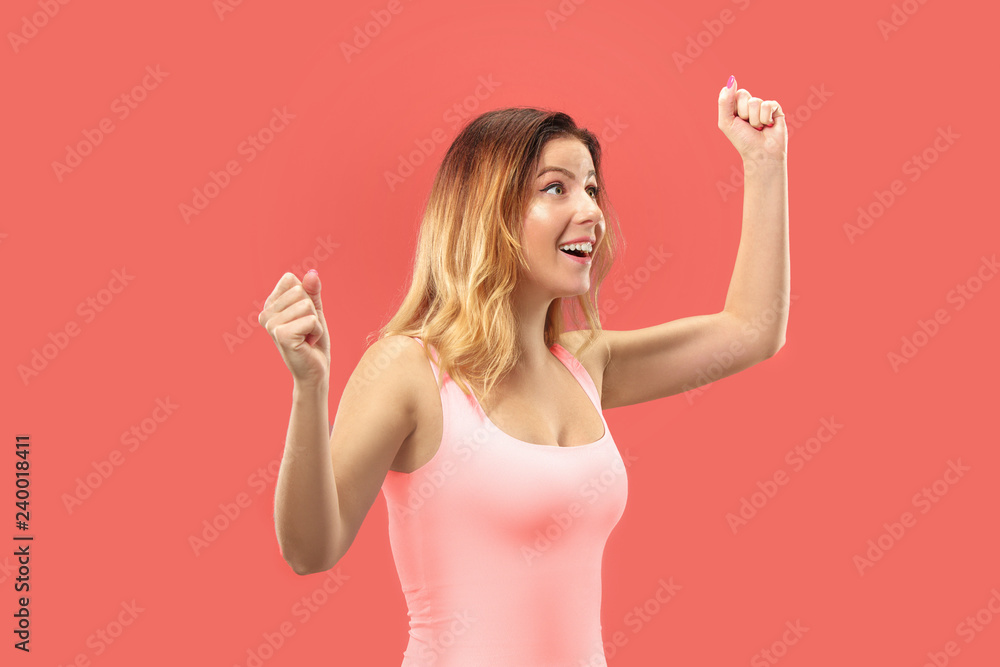 Wow. Beautiful female half-length front portrait isolated on coral studio backgroud. Young emotional surprised woman standing with open mouth. Human emotions, facial expression concept. Trendy colors Wow. Beautiful female half-length front portrait isolated on coral studio backgroud. Young emotional surprised woman standing with open mouth. Human emotions, facial expression concept. Trendy colors