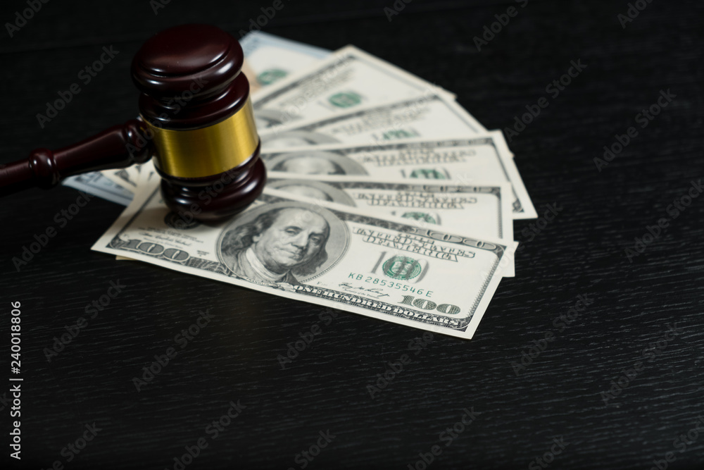 Judge's gavel on the background of dollar bills
