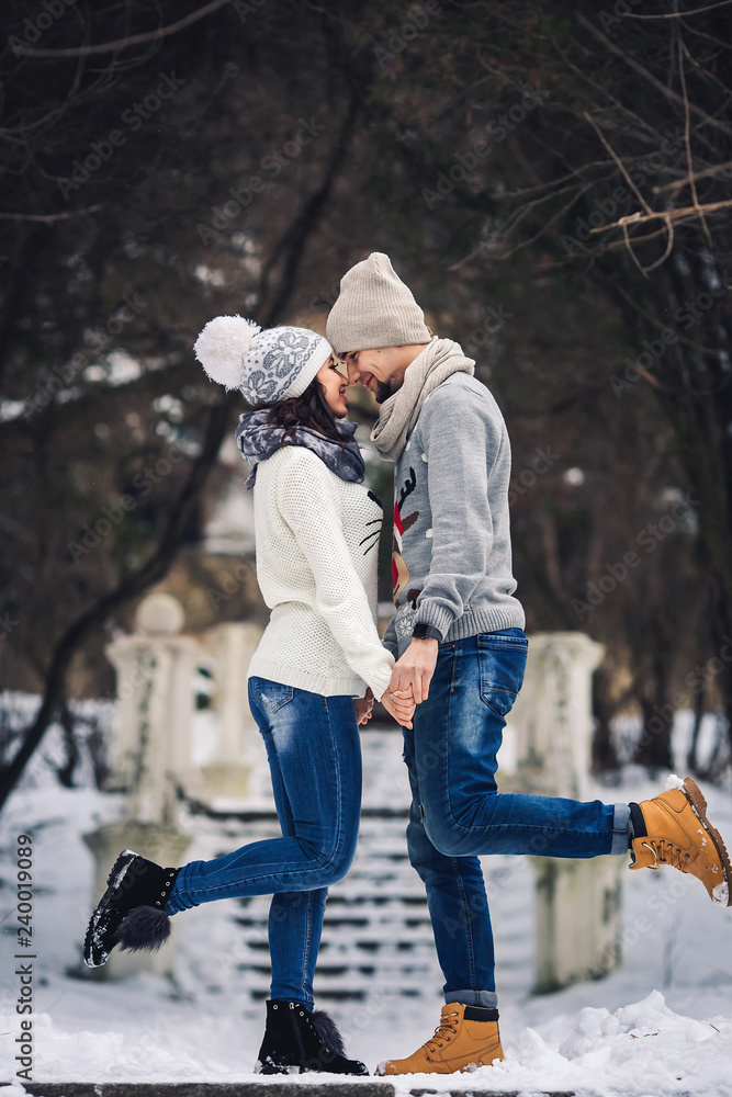 man and girl in sweaters hugging in the park in winter. winter walk, rest.